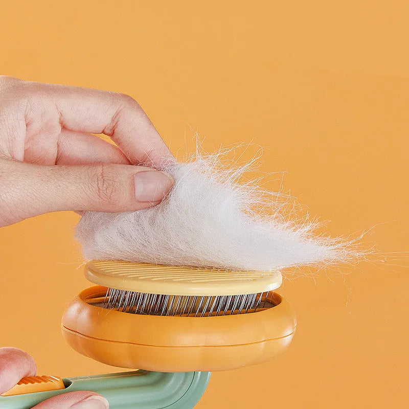 Pumpkin coloured pet grooming brush with curved stainless steel needles and a hand-held plastic handle.