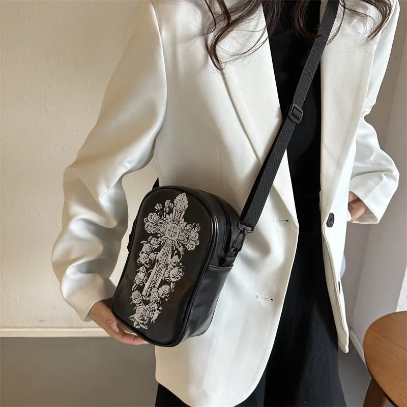 Black mini crossbody bag with Halloween graffiti print of cartoon pumpkins and bats.
