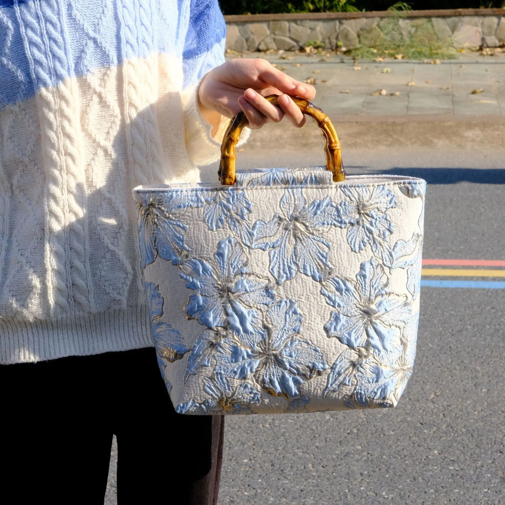 Light blue women's canvas shoulder bag with gold bronzing flower detailing showing horizontal square shape