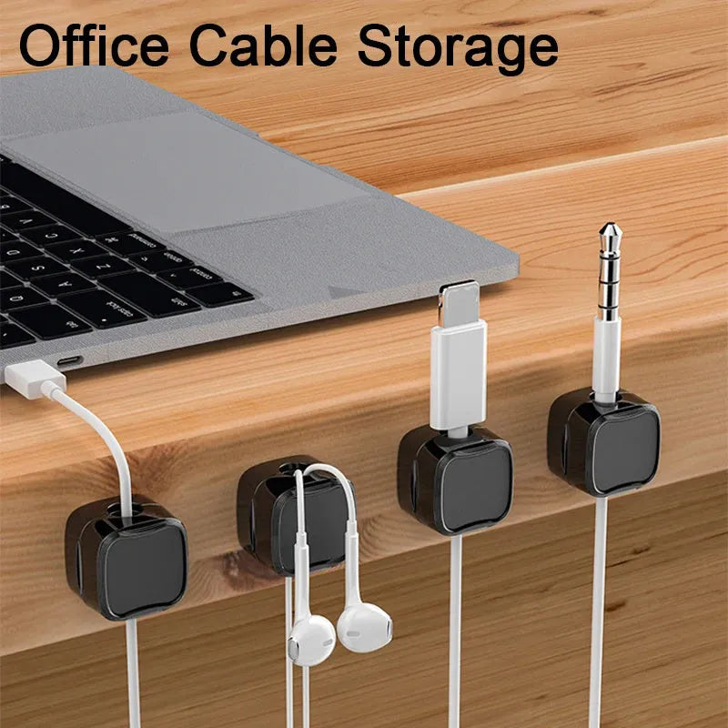 White and black magnetic under-desk cable clips organising various cables with adhesive backing