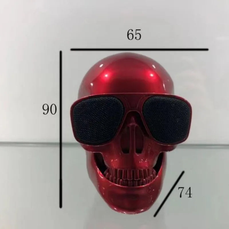 Small skull-shaped wireless Bluetooth speaker in black, portable with button controls and USB charging