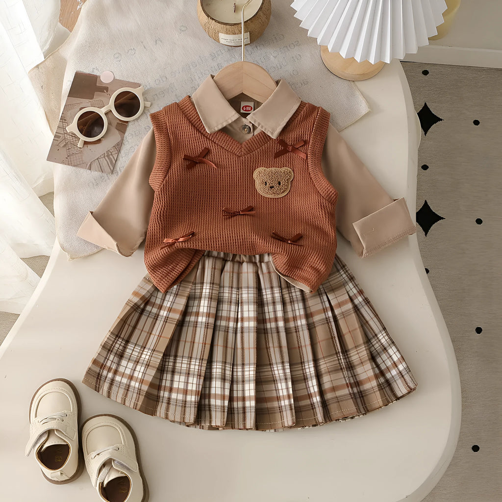 Girls' light brown plaid three-piece set with top, knitted vest, and pleated skirt on white background