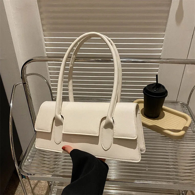 Women's small horizontal square shoulder bag in PU leather with single strap and stitching detail.
