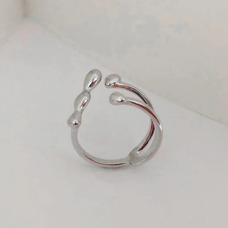 Gold and silver adjustable opening fashion ring with spherical design on a brass base.