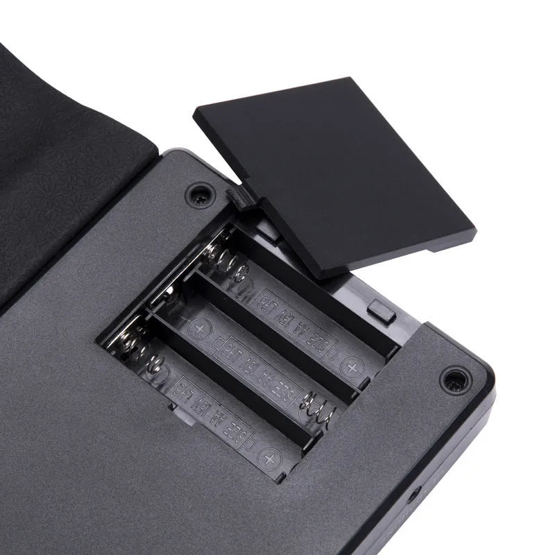 Portable 49-key folding electronic keyboard with speaker in gloss black, showing rolled design and control panel.