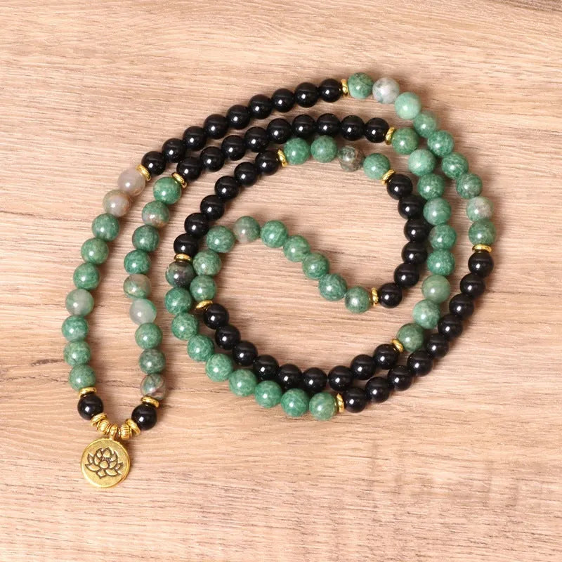 Green and black alloy bead elastic bracelet on a black stretch cord.