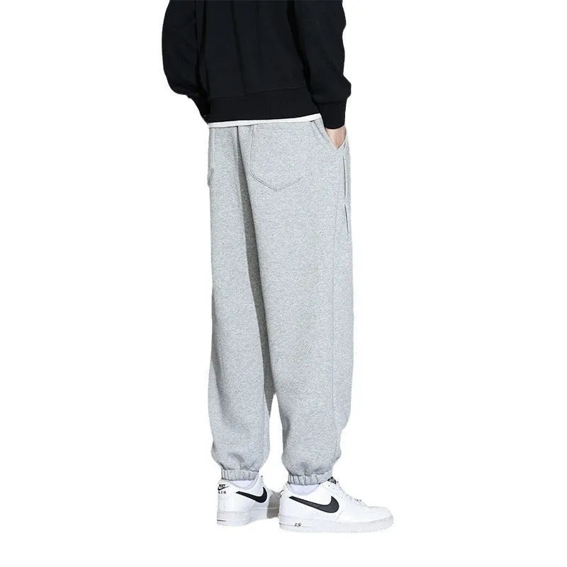 Men's loose grey casual sports trousers with drawstring waist on a plain background