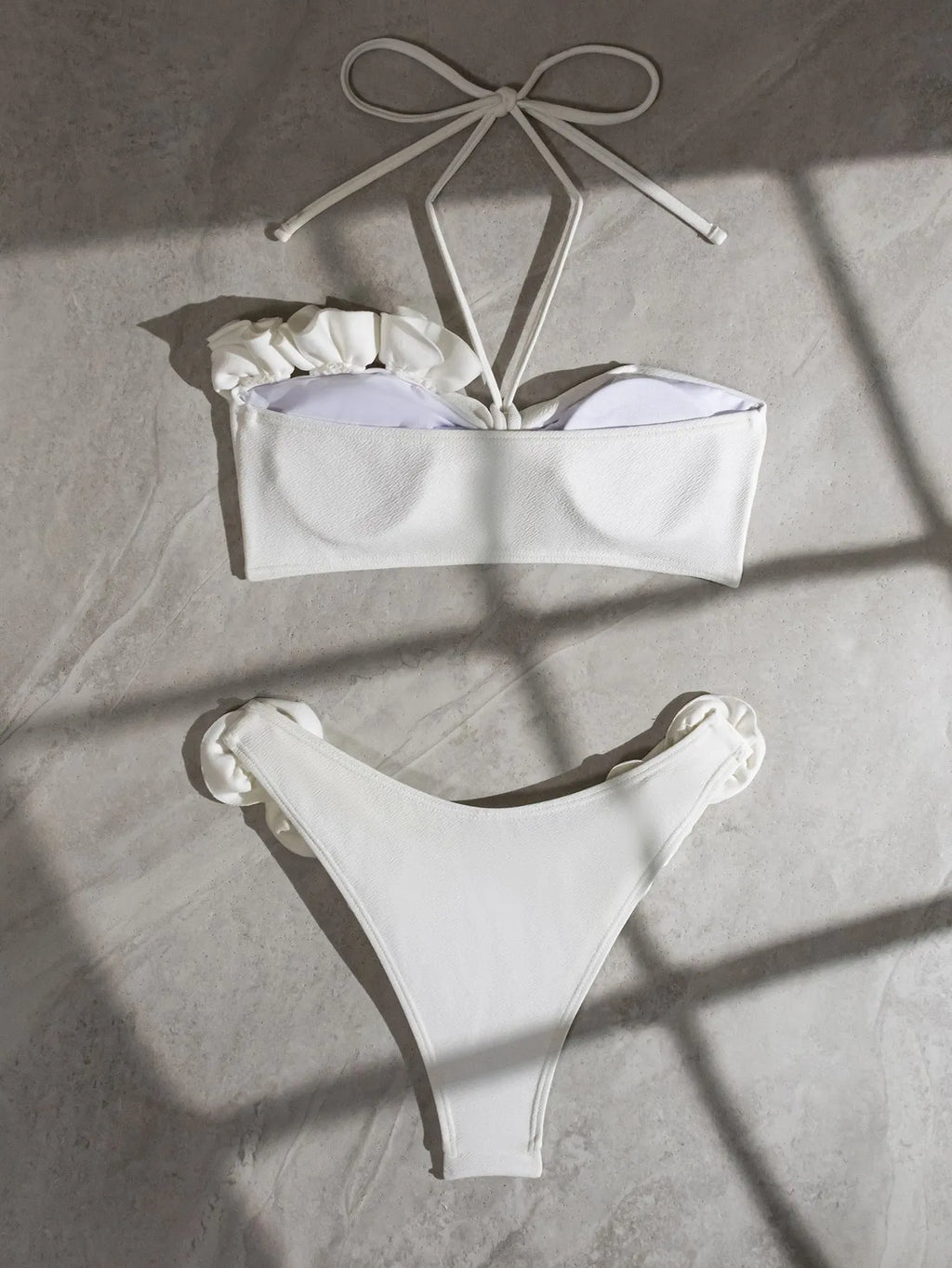 White halter neck lace-up swimsuit with three-dimensional floral details and brief bottom