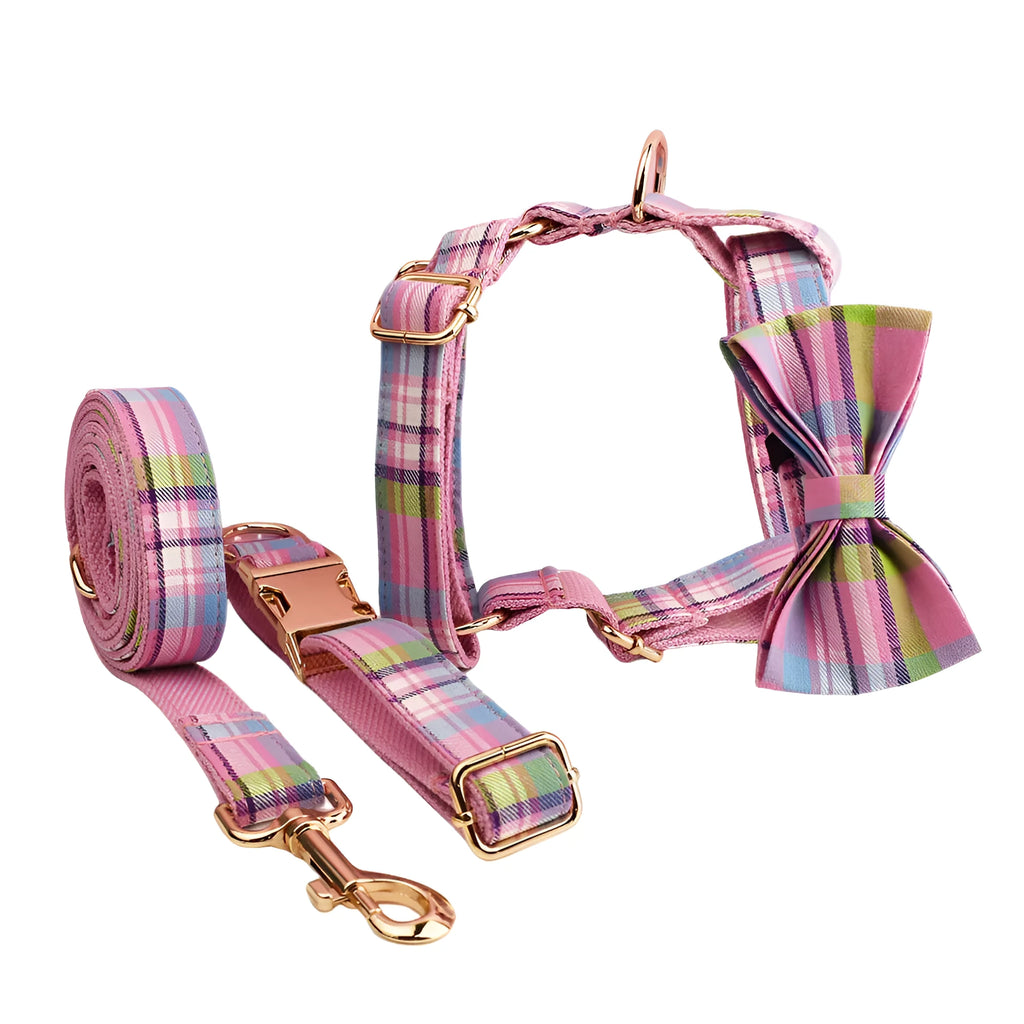 Cloth dog collar and matching lead set with a red bow and a matching dog vest laid out flat.