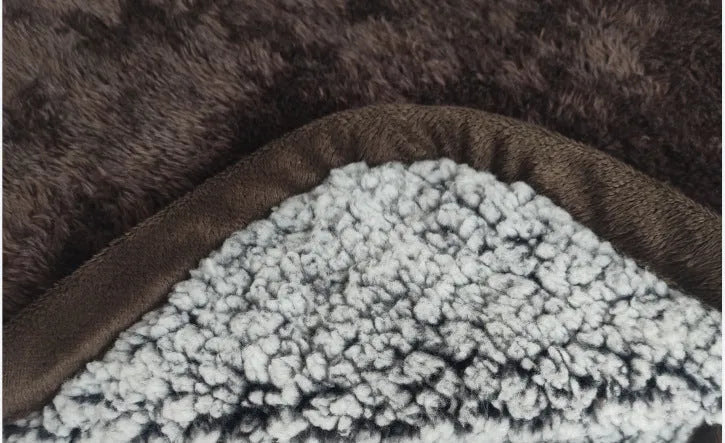 Waterproof urine proof pet blanket in grey with black and white bottom on a kennel bed
