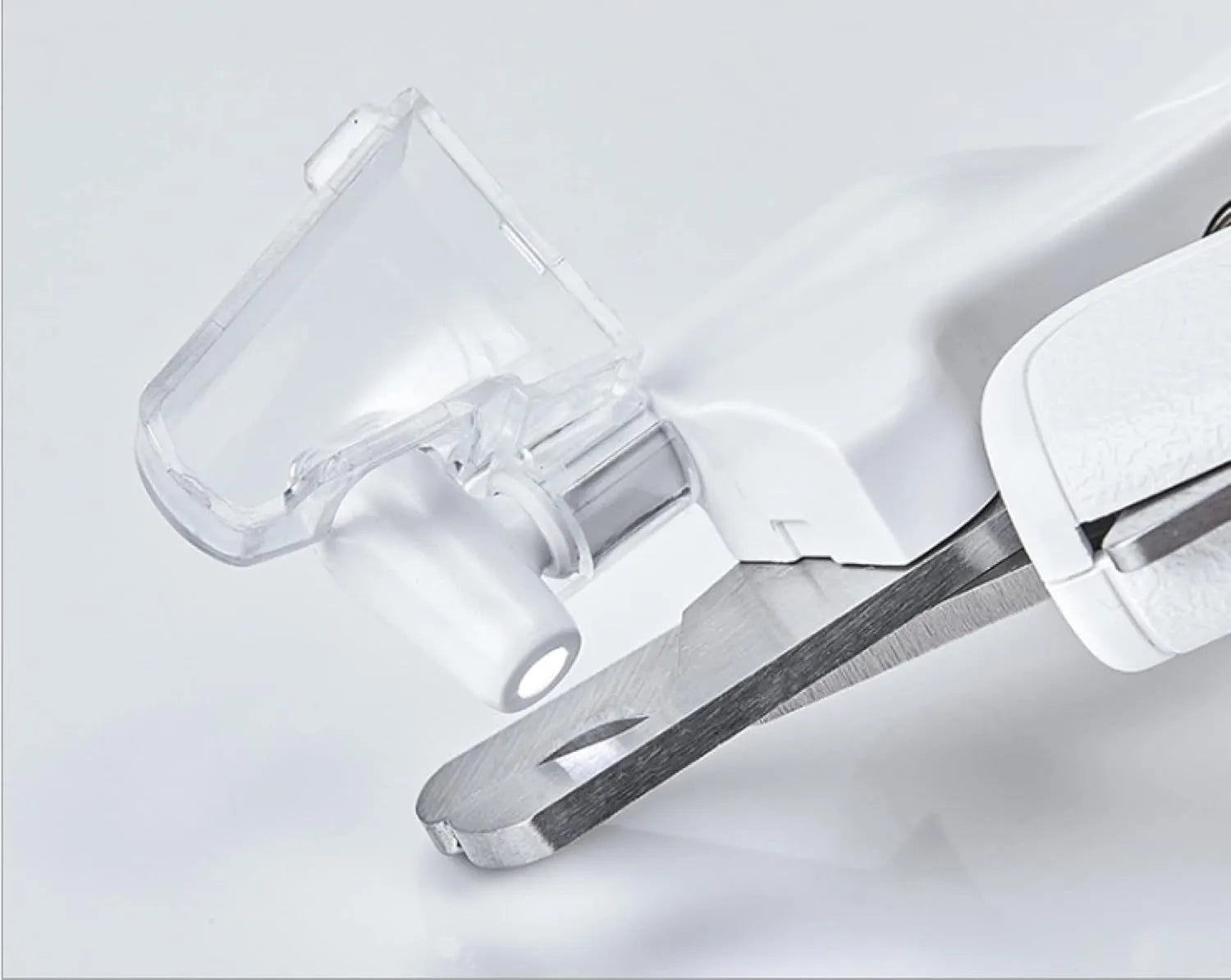 White pet nail clippers with LED light, transparent guard, and built-in file for cats and dogs.