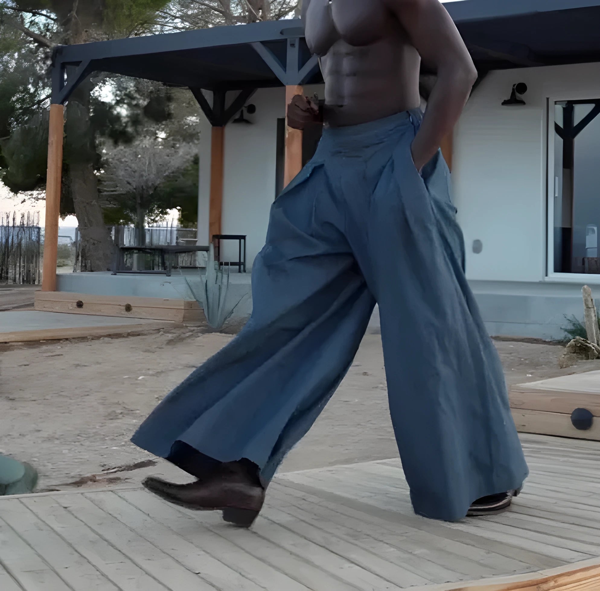 Men's grey pleated wide-leg trousers with an elastic drawstring waistband laid flat.