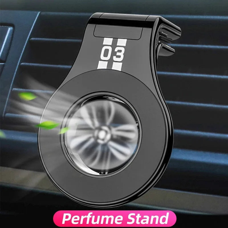 Black magnetic car air vent phone holder with adjustable head and fragrance slices attached to a vehicle vent.
