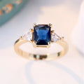 Rectangular copper ring with gold sapphire blue finish shown on model finger