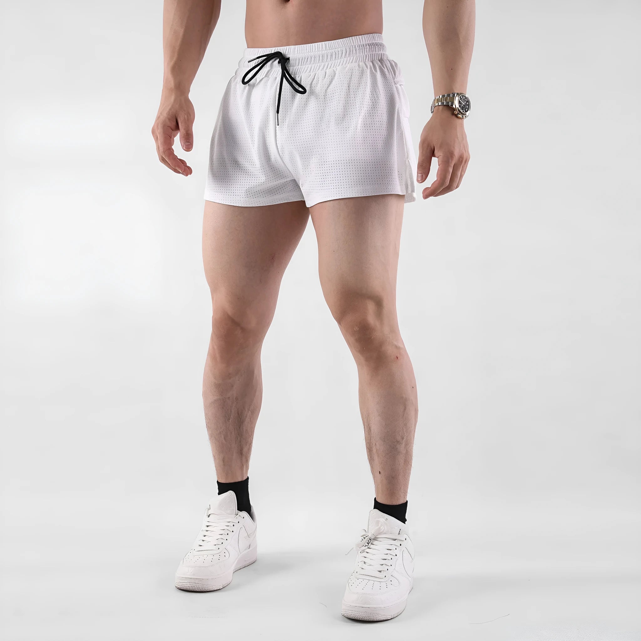 A pair of men's nylon summer shorts in black, showing the mid-waist design and short length for sports.
