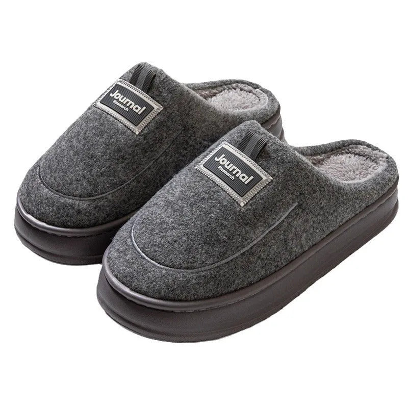 Men's brown suede slippers with a thickened sole on a wooden floor