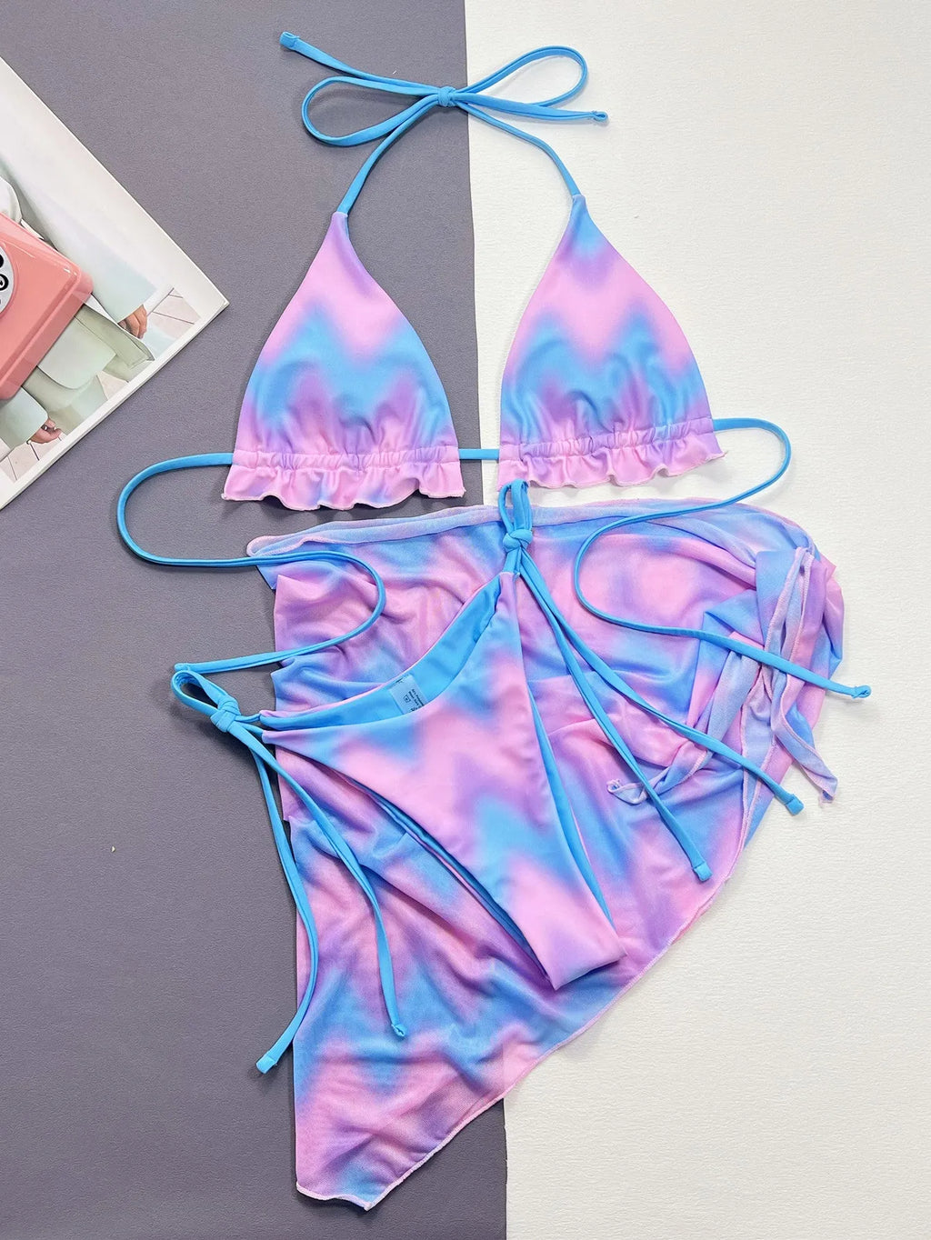 Women's tie-dye bikini swimsuit set with a skirt, bra, and matching briefs.
