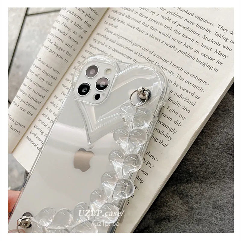 Transparent soft TPU iPhone case with a decorative silver love bracelet chain attached.