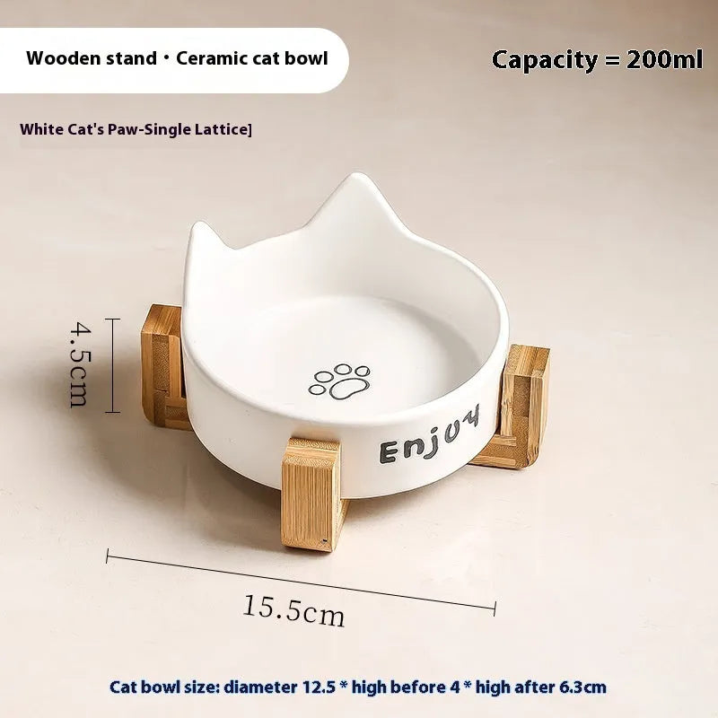 Porcelain cat bowl with cat ear handles in a wooden anti-tumble frame, showing paw print design.