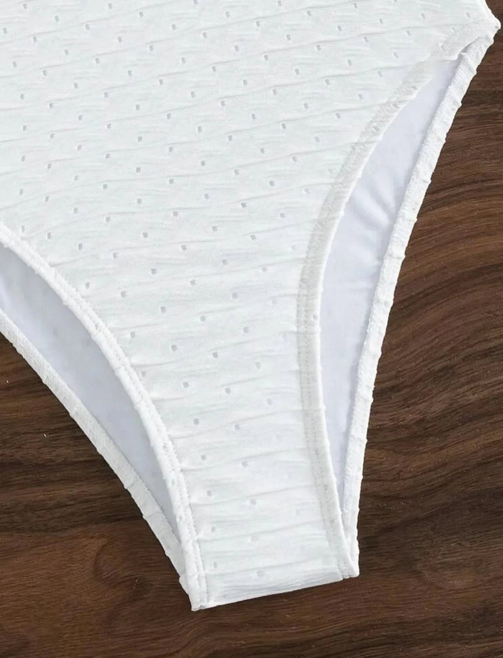 White one-piece women's swimsuit with sling straps and brief styling on mannequin