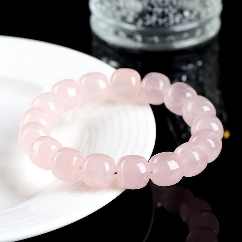 Pink crystal barrel bead bracelet with geometric design on a wrist.