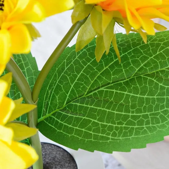 Rechargeable artificial sunflower LED night light on a table with USB cable.