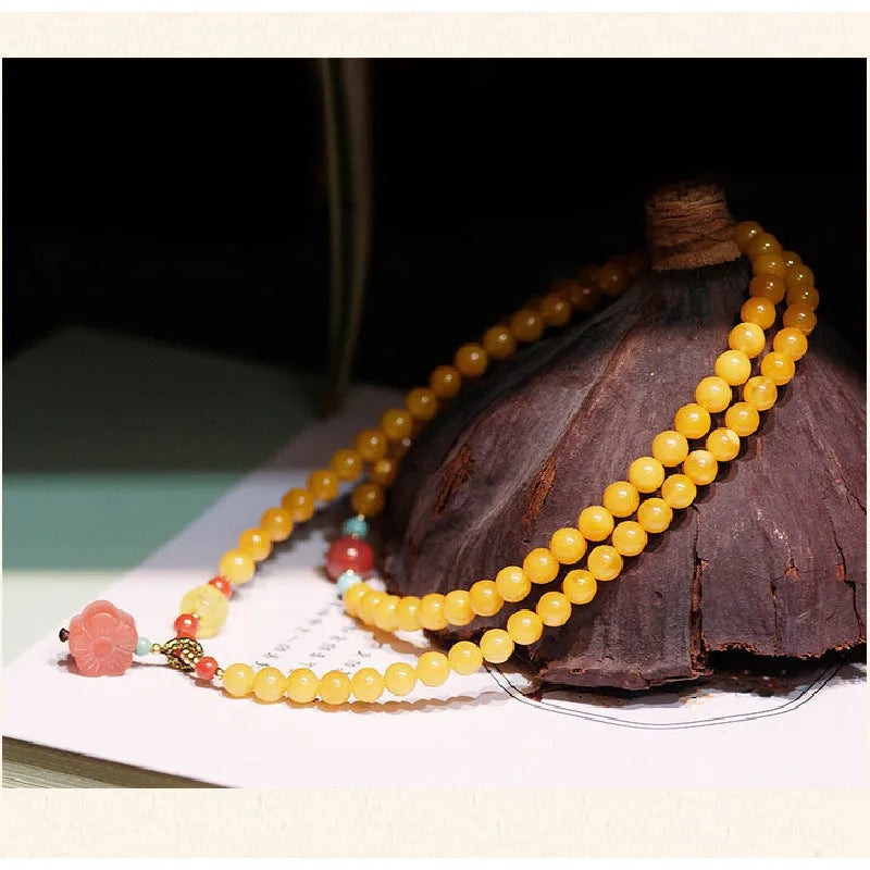 Yellow amber bracelet with 5mm round beads and an animal zodiac charm on a white background.