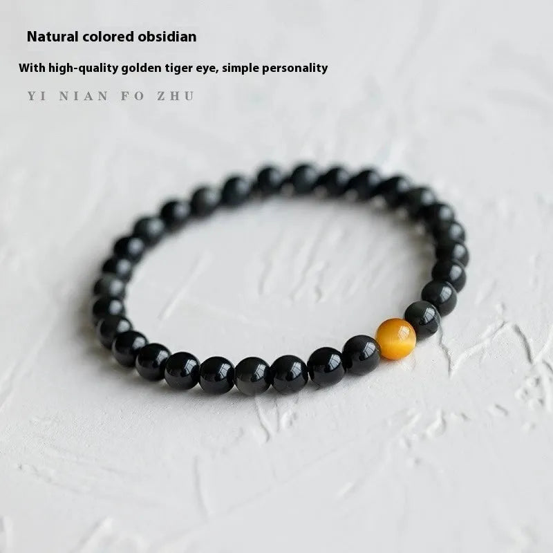 Natural black obsidian geometric bead bracelet on an adjustable string, showing 10mm bead size.