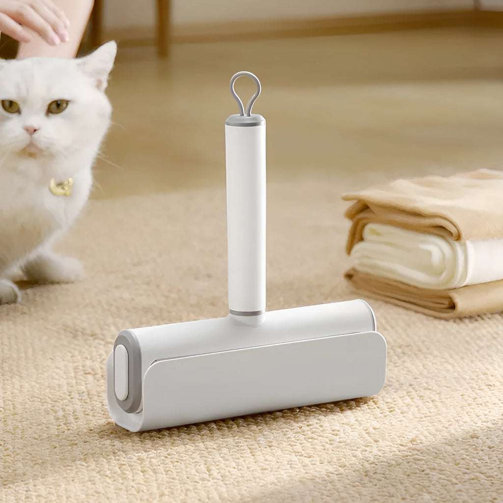 Reusable plastic lint remover roller with a long adhesive paper roll for pet hair and dust on floors.