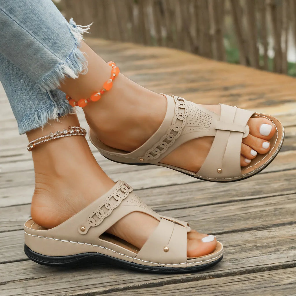 Women's blue Roman style slope heel slippers with fish mouth toe holder on a wooden floor.