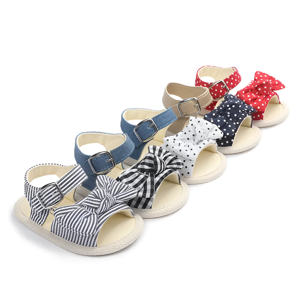 White and black low tube baby shoes with Velcro strap closure for toddlers.