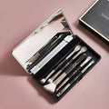 Makeup brush set with mirror showing artificial fibre bristles and plastic handles
