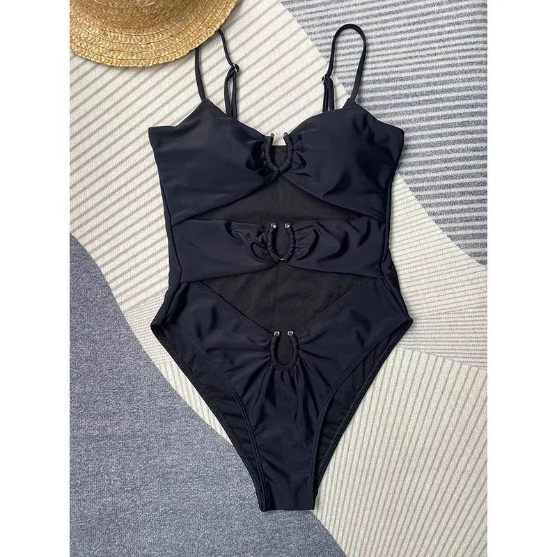 Black women's one-piece swimsuit on hanger showing solid colour design and contemporary cut