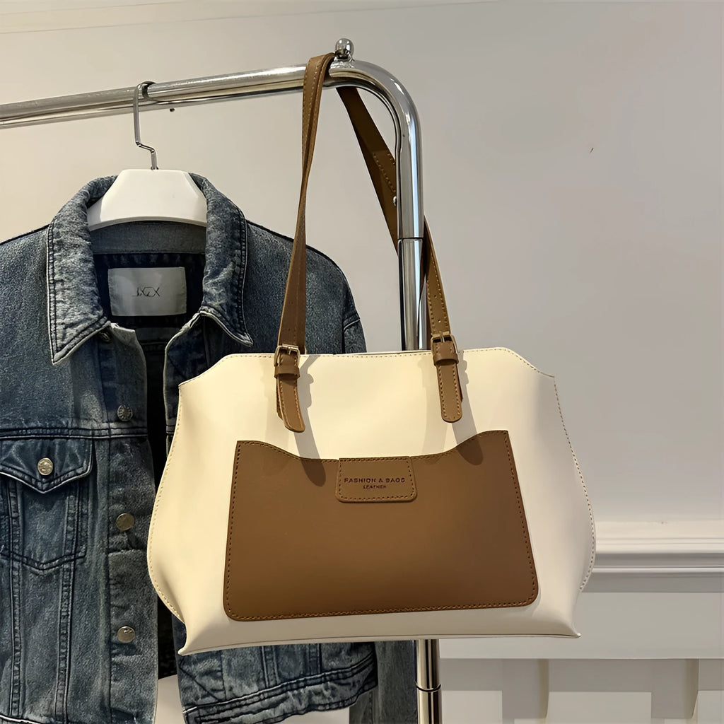 Women's black PU tote bag with shoulder straps showing internal mobile phone pocket