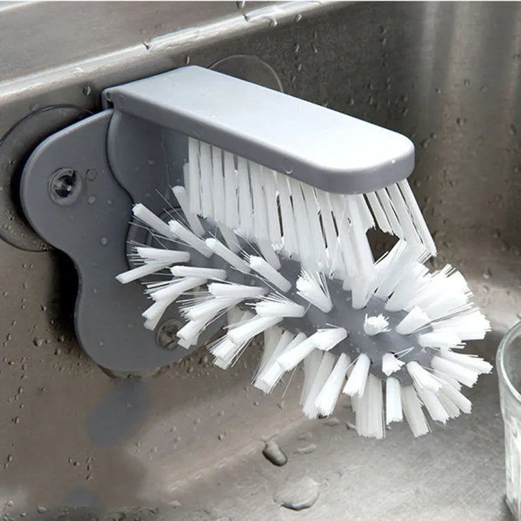 Grey 2-in-1 cup scrubber with double-sided bristles and three suction cups on a white surface