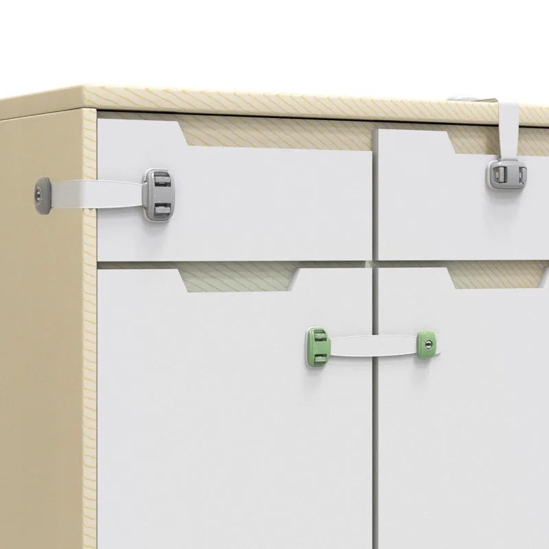 Grey adjustable child safety strap lock with adhesive pads, shown securing a kitchen cabinet door.