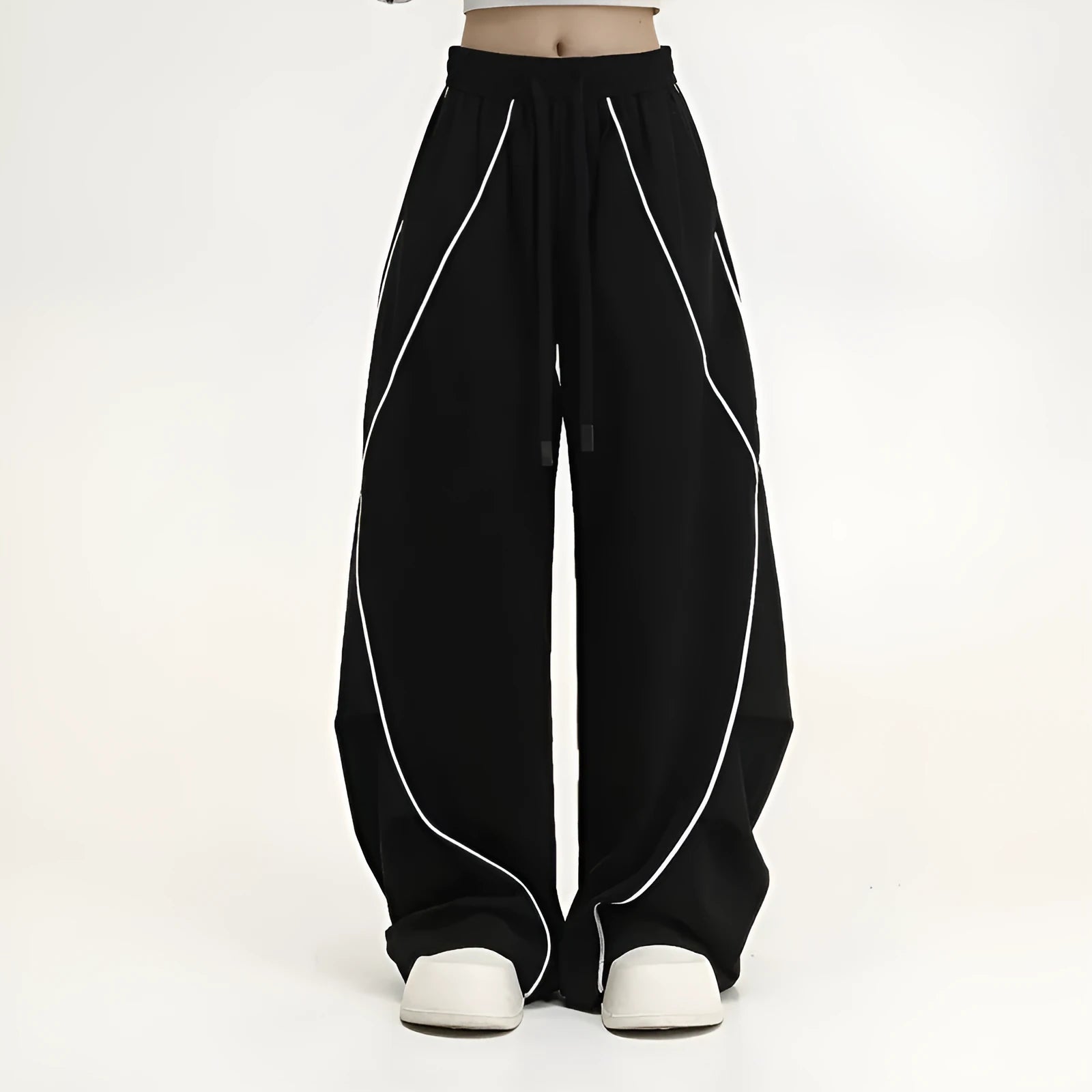 Black striped wide-leg sports pants with pleated detail on a mid-waist, loose fit.