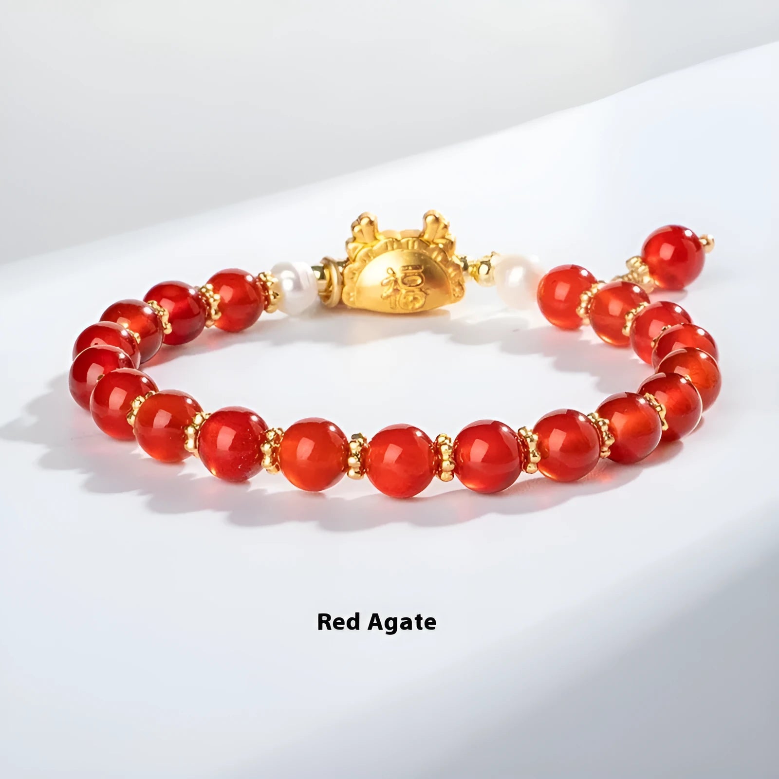 Natural agate bracelet with diamond-shaped beads and a dragon zodiac charm on a wrist.
