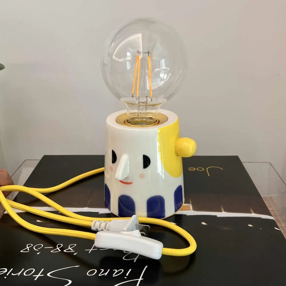 Handmade ceramic bedside lamp with ball headlight colour finish on a table.