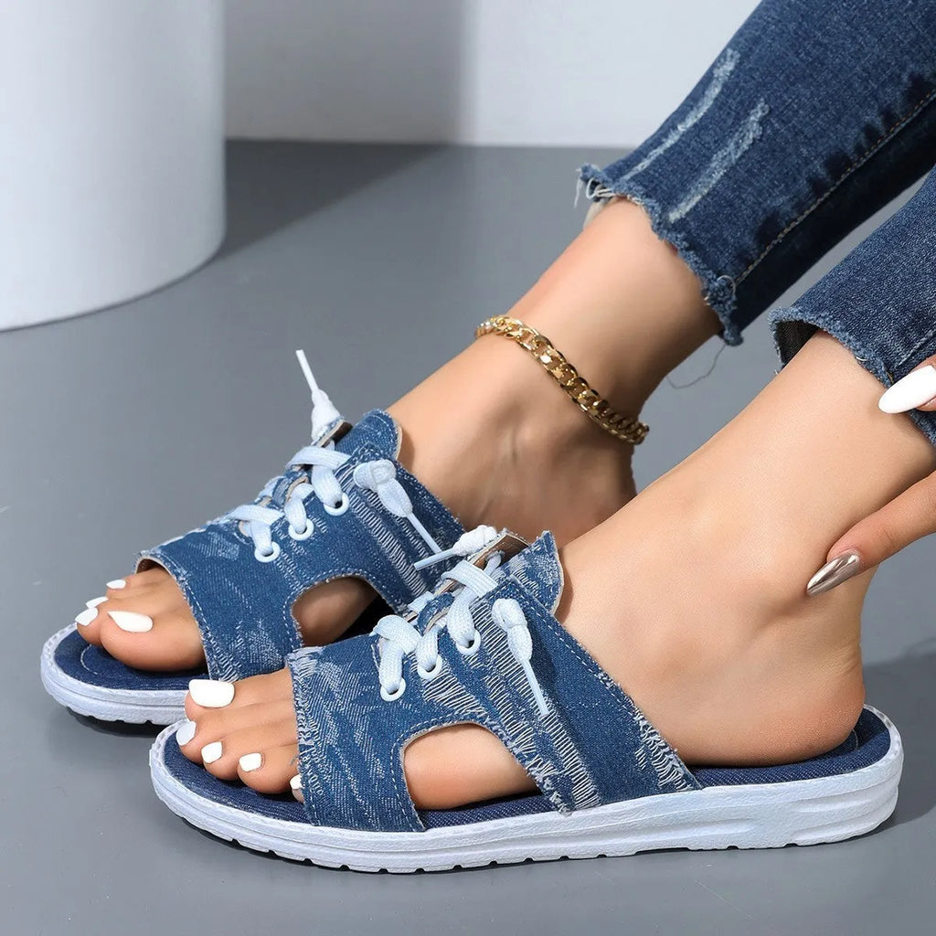 Blue women's flat canvas slippers with cloth lining and a rubber sole, shown in Roman style.