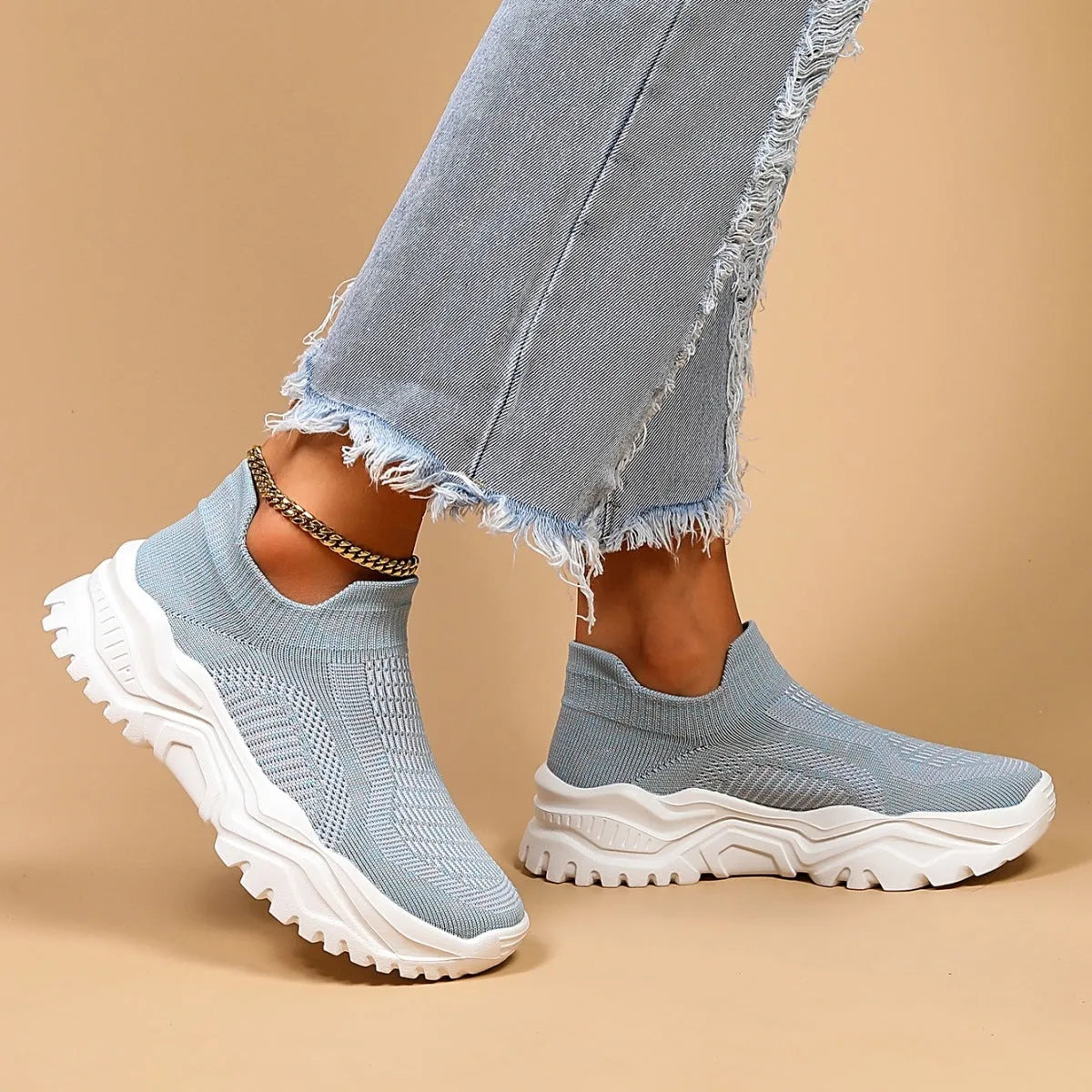 Light blue women's mesh slip-on sports shoes with a round toe and mid heel on a white background.