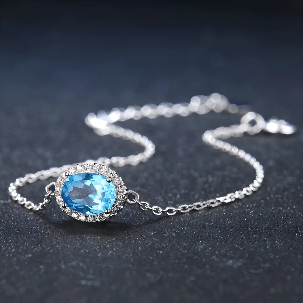 925 sterling silver four-piece jewellery set with blue topaz gems showing geometric earrings, ring, necklace, and pendant
