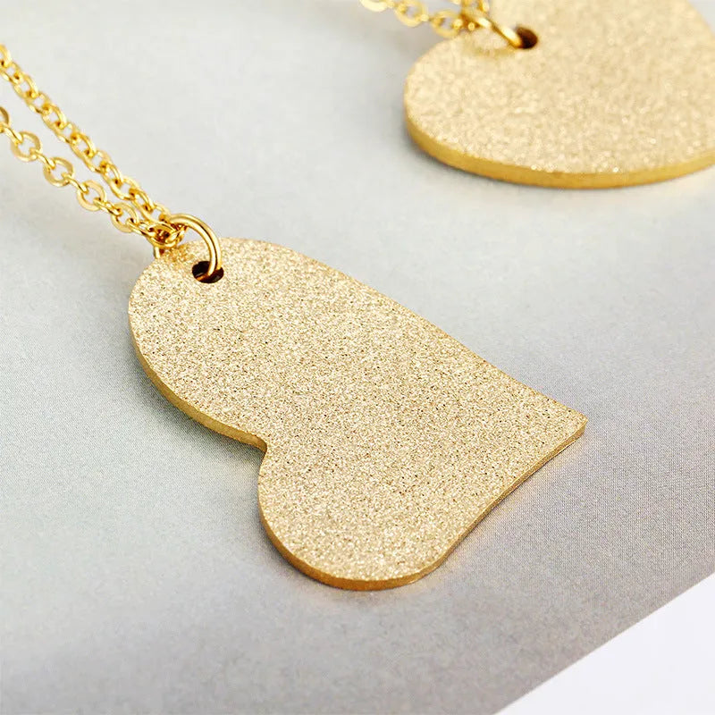 Geometric titanium steel pendant necklace with a heart-shaped neckline design in a metallic finish.