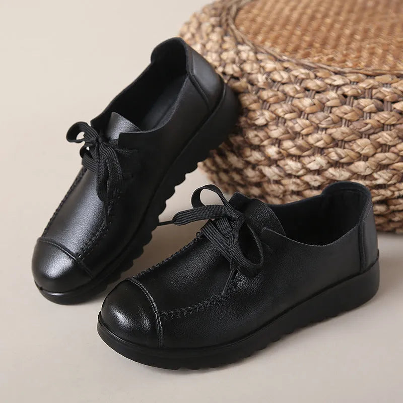 Women's black round toe flat work shoes with front lacing and soft anti-slip polyurethane sole