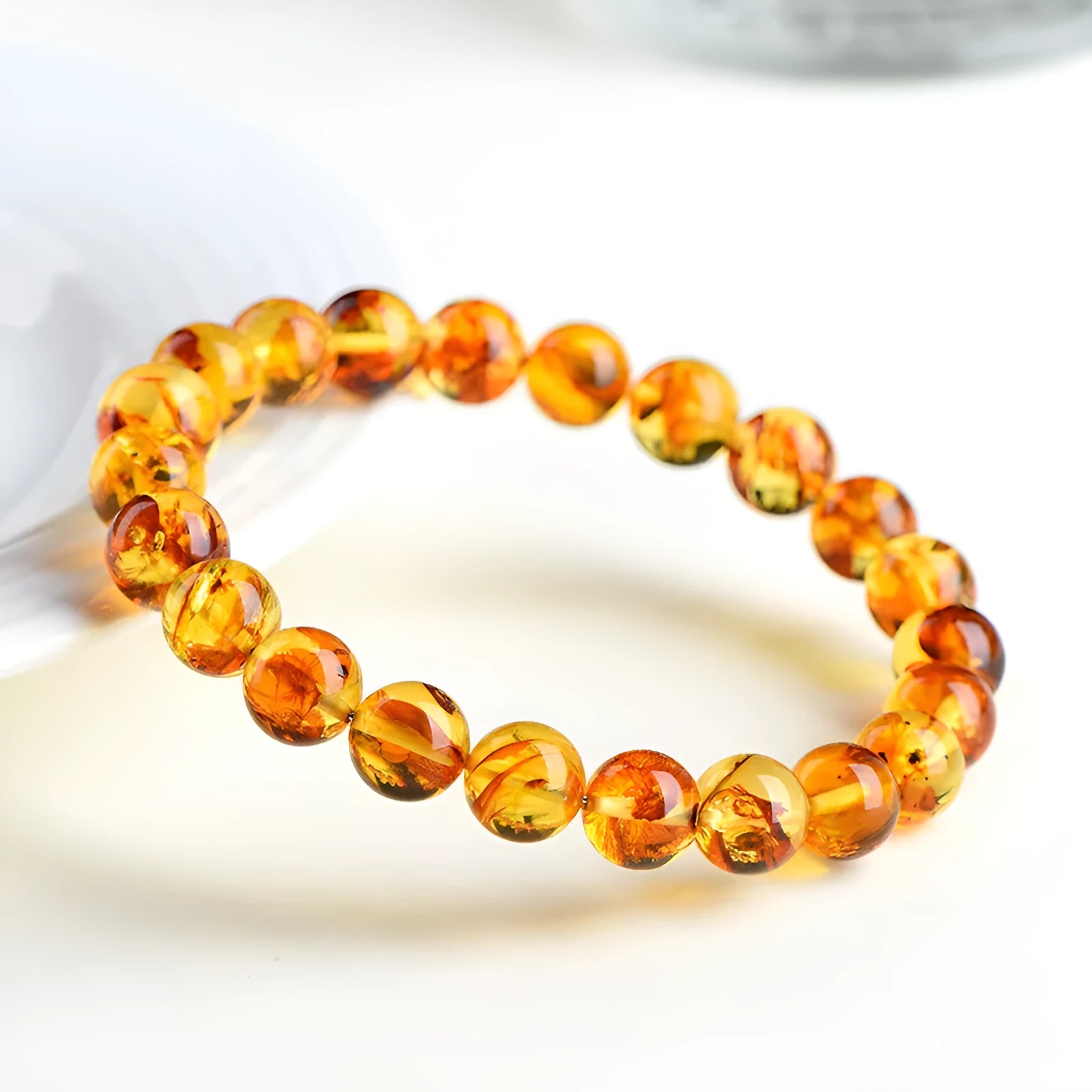 Natural yellow piebald amber geometric bracelet on a wrist, showing polished beads with flower spot patterning.