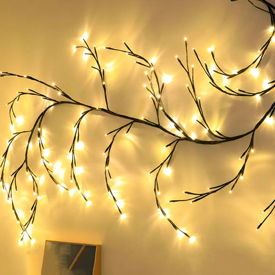 Flexible LED willow vine garland with warm white lights bent into a decorative shape on a wall.