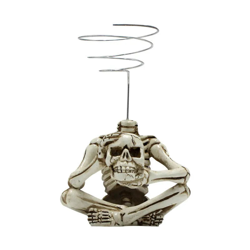 Gothic resin air plant bracket with skull ornament on iron base.