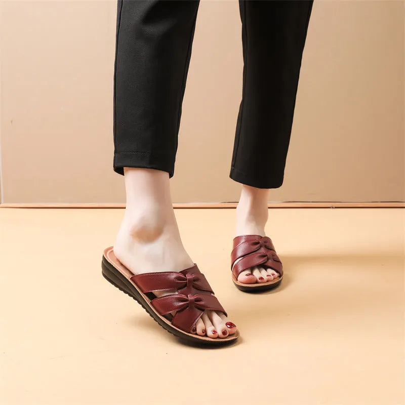 Women's beige cowhide slippers with a soft sole and synthetic leather lining, shown in a sandal style.