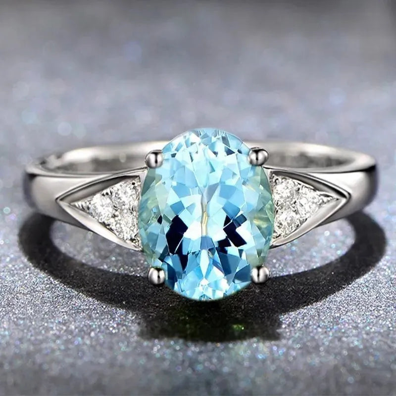 Women's court-style ring with natural zircon inlay in heart, drop, or bell patterns on a blue background.