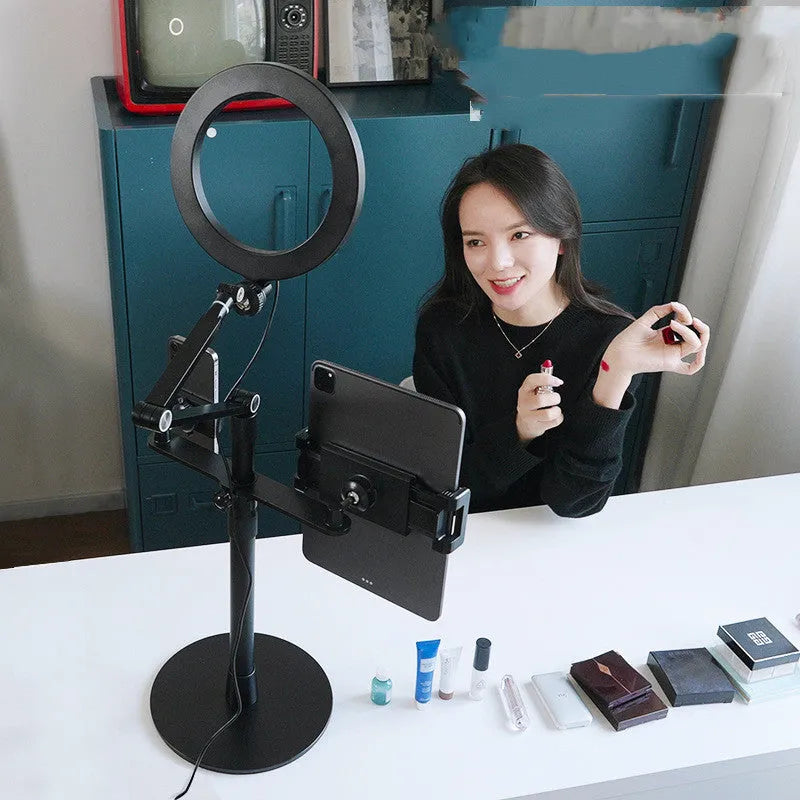 Black aluminium floor stand with fill light holding a mobile phone for video shooting.